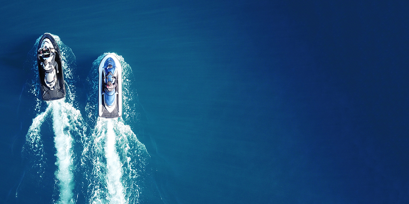 Aerial drone top view of jet skis cruising in deep blue sea