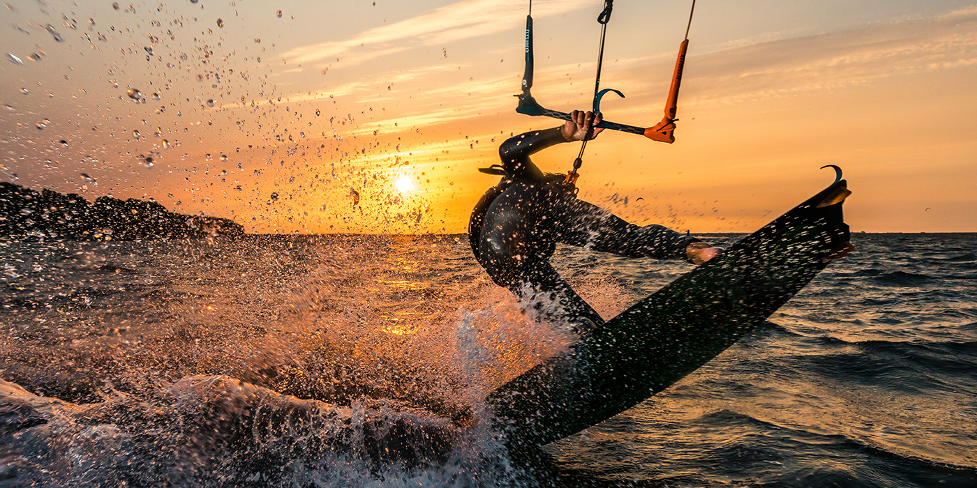 Flash photo of kitesurfer in beautiful yellow sunset at the balt